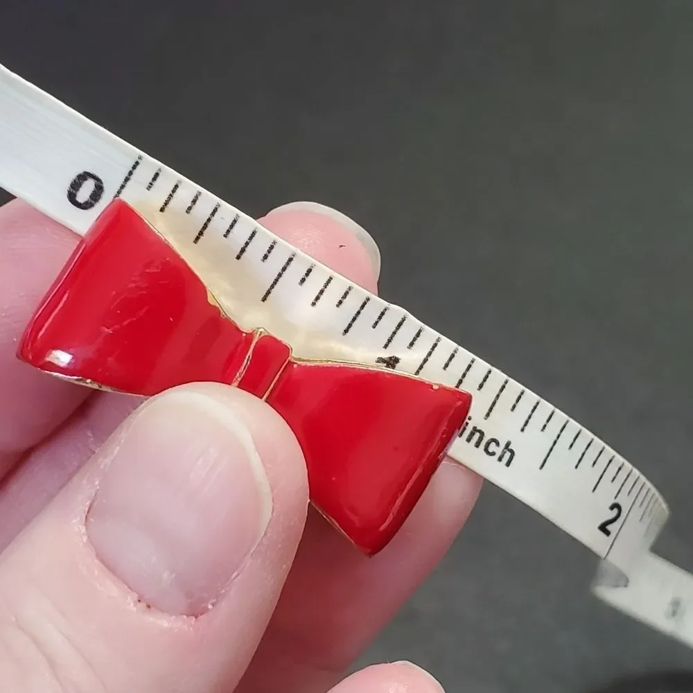 Gold tone red enamel bow ring currently a 7